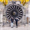 Engineers working on aircraft engine manufacturing UK assembly line inside modern aerospace plant