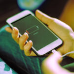 A girl is plugging in charging cable to charge phone