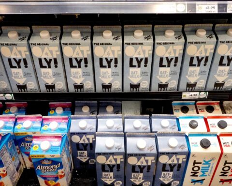 Oat drink being poured into glass amid Oatly UK ruling labeling debate
