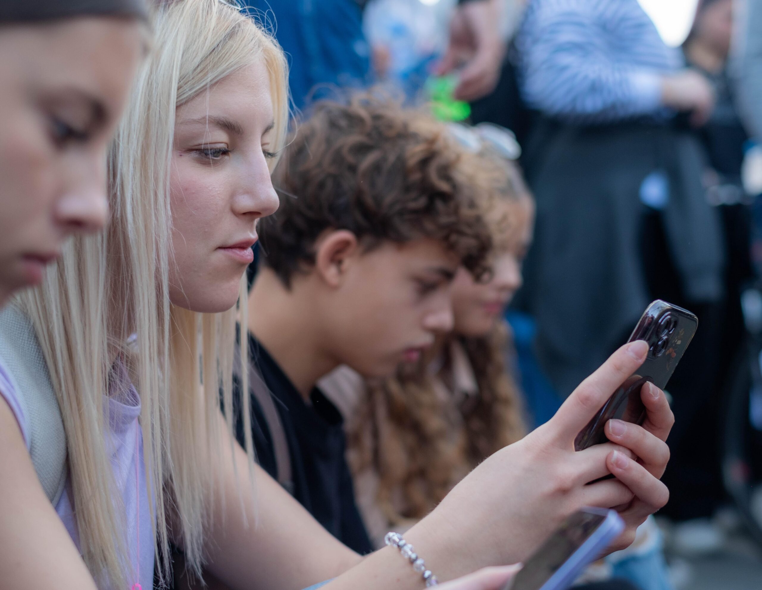 Teenagers using smartphones amid child online safety Germany concerns