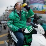 Delivery driver facing platform economy challenges due to high fuel costs in Vietnam