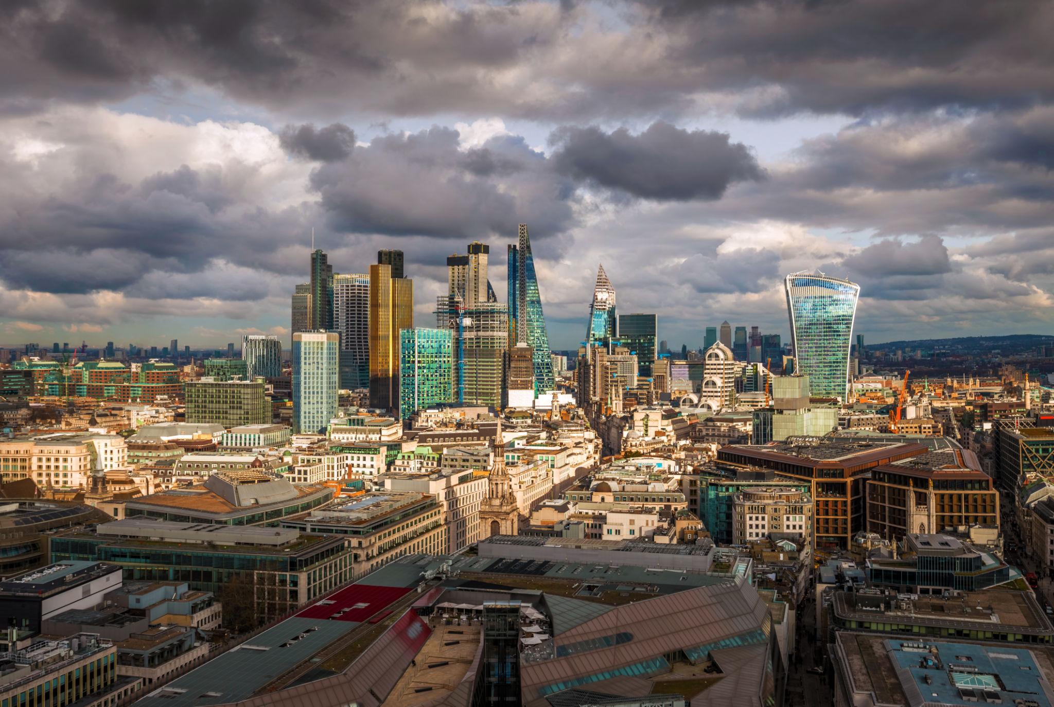 UK investment funds performance showing London financial district skyline Canary Wharf