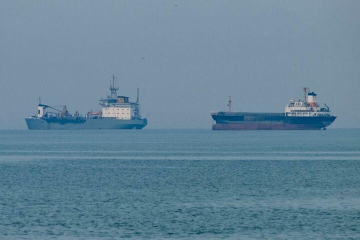 Global oil supply route risk with military escort ships accompanying oil tankers through high-risk waters