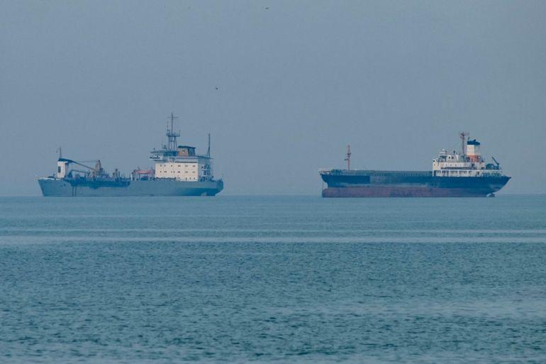 Global oil supply route risk with military escort ships accompanying oil tankers through high-risk waters