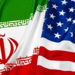 Diplomats meet during Iran US negotiations with US and Iran flags displayed