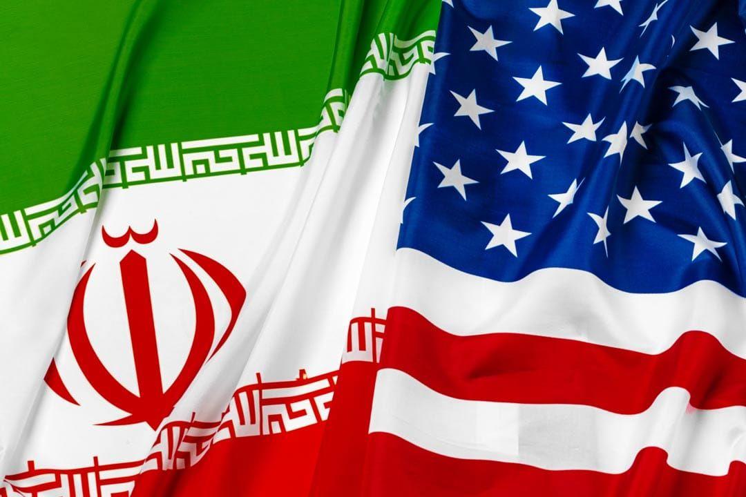 Diplomats meet during Iran US negotiations with US and Iran flags displayed