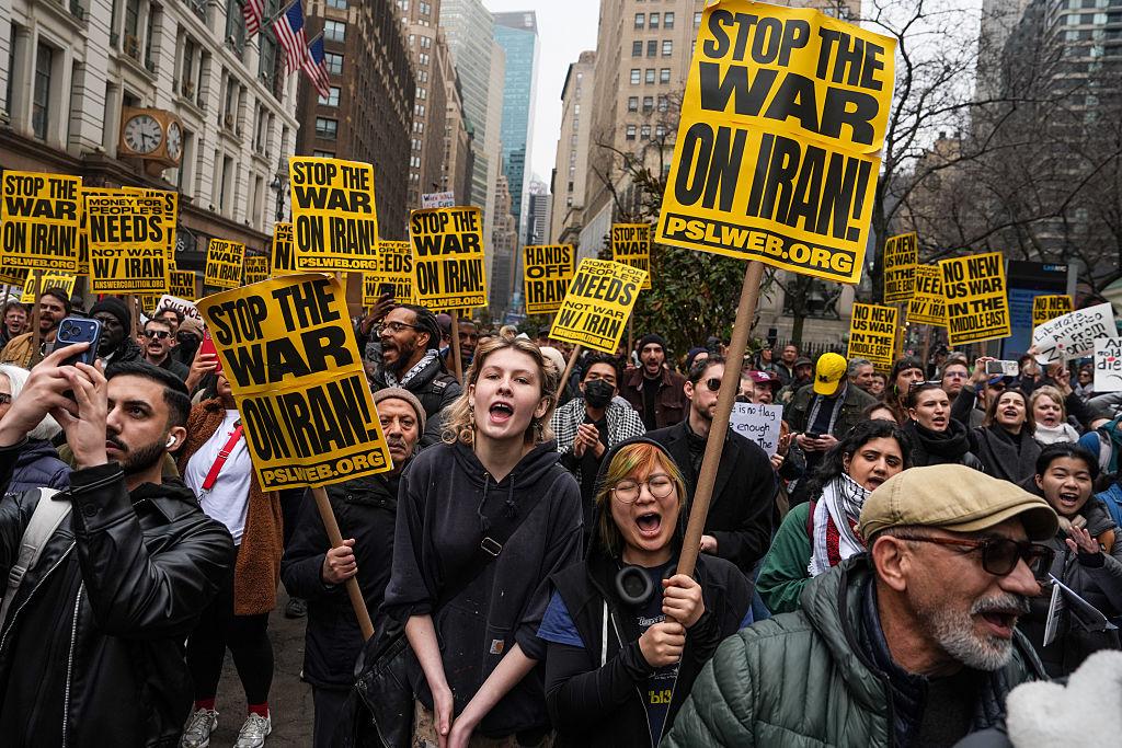 US Iran War Protests Expand as Top Security Official Resigns 1 US Iran war protests protesters holding anti war signs USA