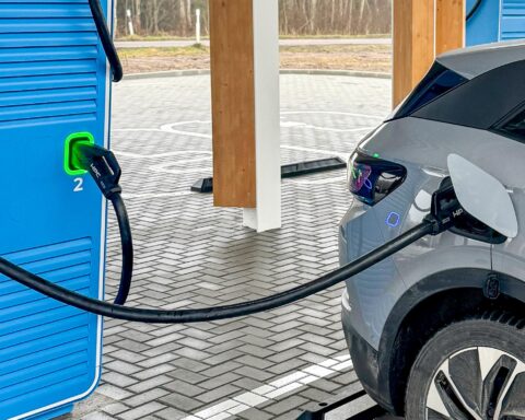 Electric SUV charging at fast station amid EV market slowdown in 2026
