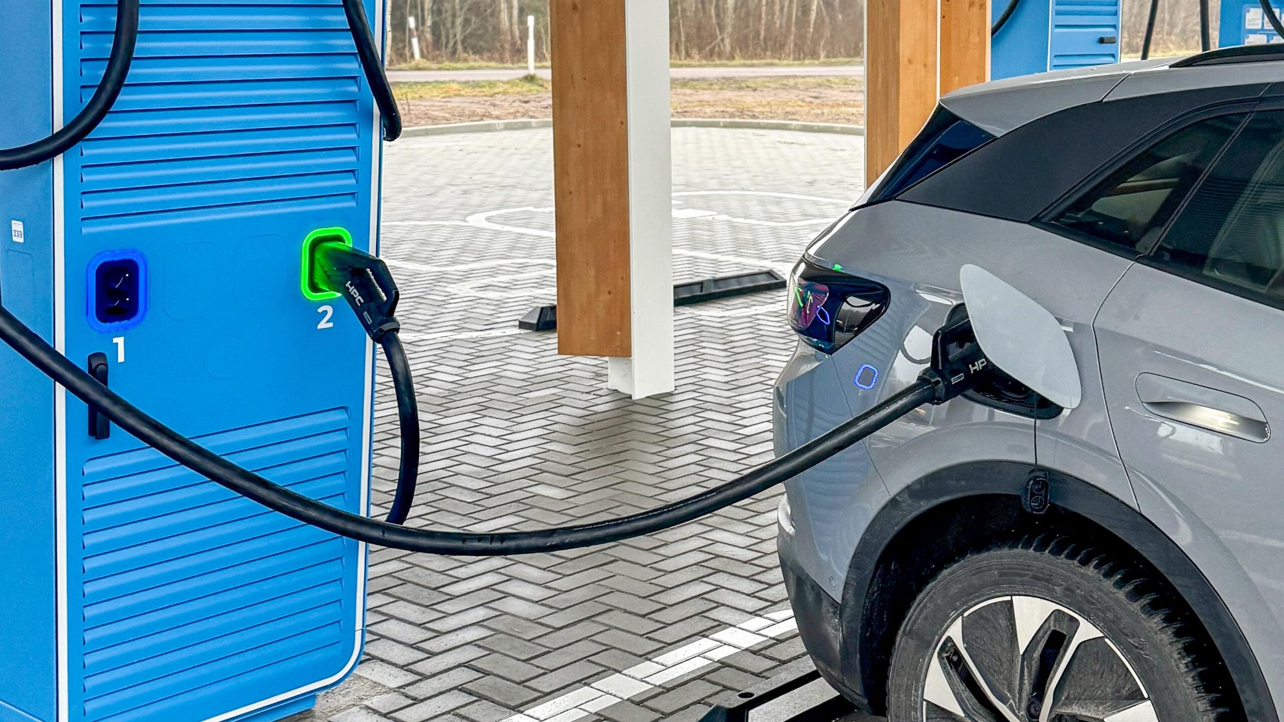 Electric SUV charging at fast station amid EV market slowdown in 2026