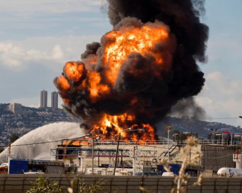 Haifa oil refinery strike aftermath with visible damage and smoke in Israel
