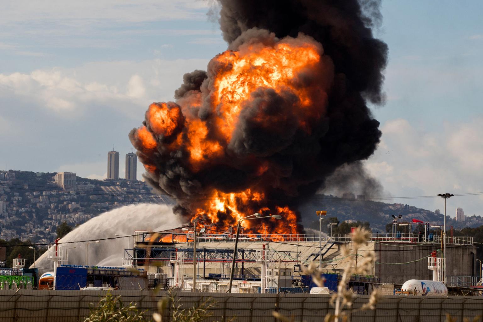 Haifa oil refinery strike aftermath with visible damage and smoke in Israel